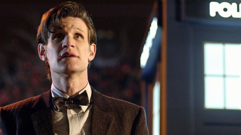 Matt Smith in suit and bowtie standing next to police box as the Eleventh Doctor in Doctor Who