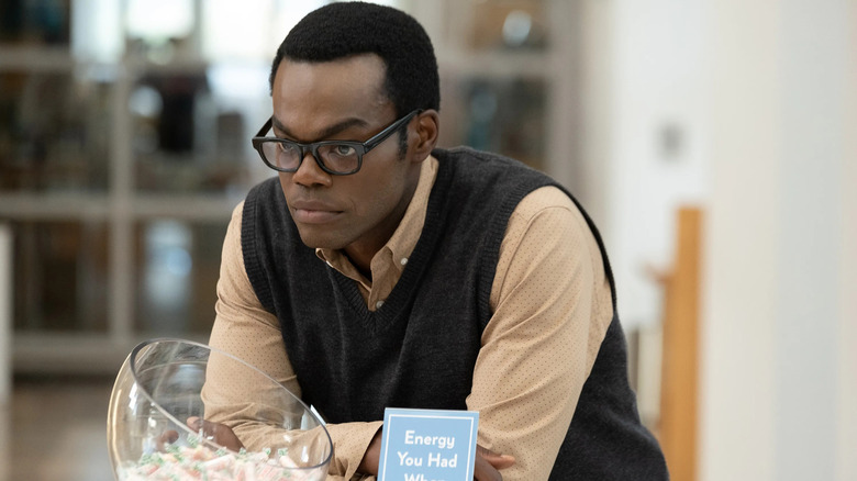 William Jackson Harper as Chidi Adagonye looking solemn next to a bowl of candy in The Good Place