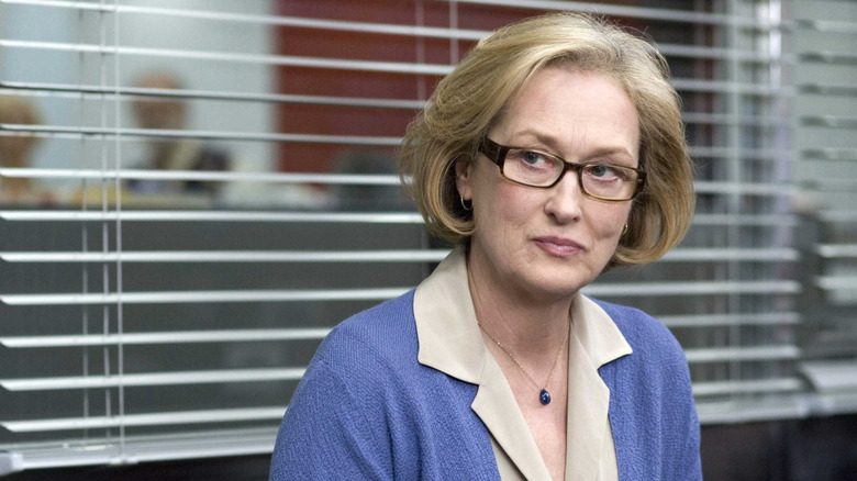 Meryl Streep smiling as Janine, sitting in an office in Lions for Lambs