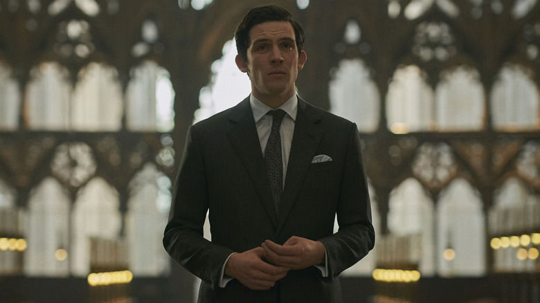 Josh O'Conner como Príncipe Carlos de pie en una iglesia de la corona