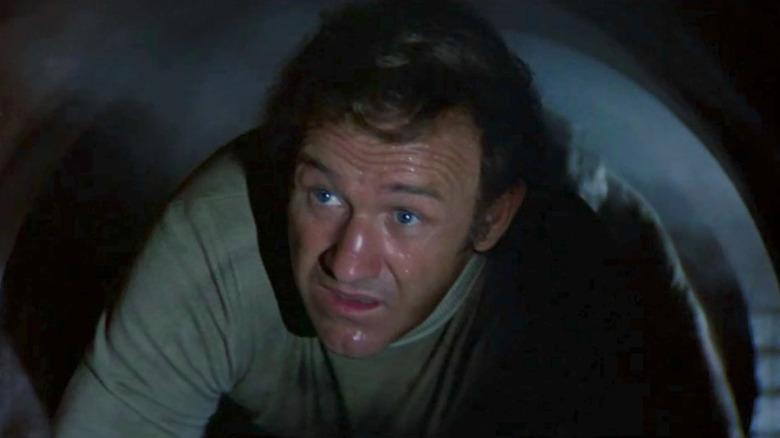 Frank Scott (Gene Hackman) crawls through a tube in The Poseidon Adventure