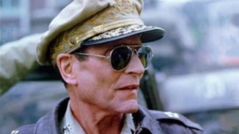 Douglas MacArthur (Laurence Olivier) rides a jeep in Inchon