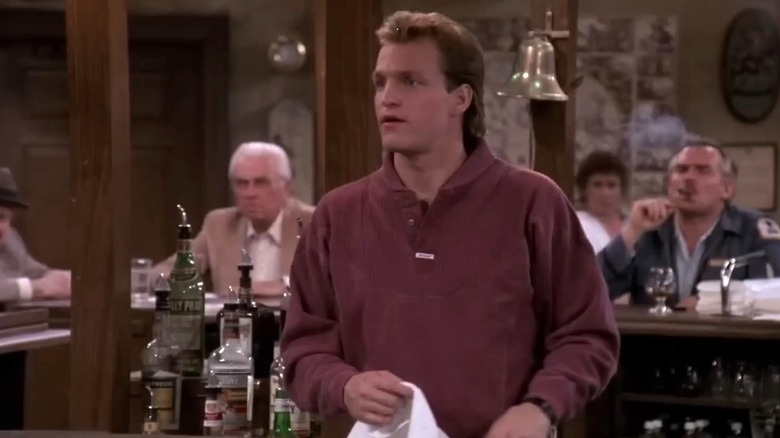 Woody Harrelson as Woody Boyd holding a towel on Cheers
