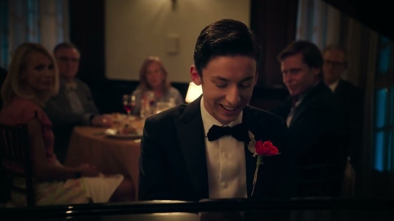 Andrew Barth Feldman as Percy playing a restaurant piano in a tuxedo in No Hard Feelings