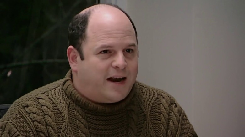 Jason Alexander as himself talking while wearing a green sweater in Curb Your Enthusiasm