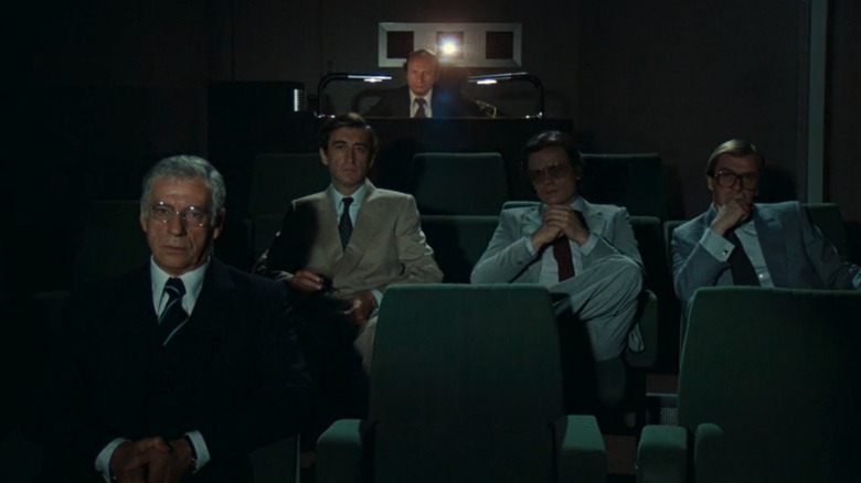 Yves Montand as Henri sitting in a private theater with other men in I for Icarus