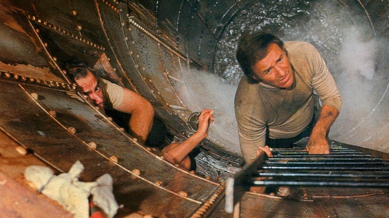 Mike Rogo (Ernest Borgnine) and Frank Scott (Gene Hackman) look up a ladder with steaming water below them in The Poseidon Adventure