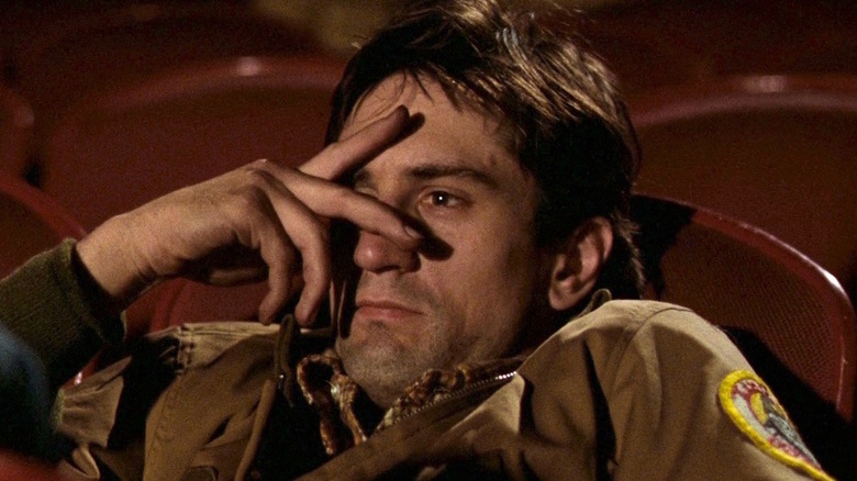 Robert De Niro as Travis Bickle, sitting in a movie theater, in Taxi Driver