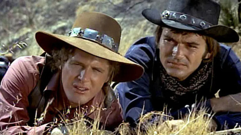 Hannibal Heyes (Pete Duel) and Kid Curry (Ben Murphy) take cover on the ground in Alias Smith and Jones