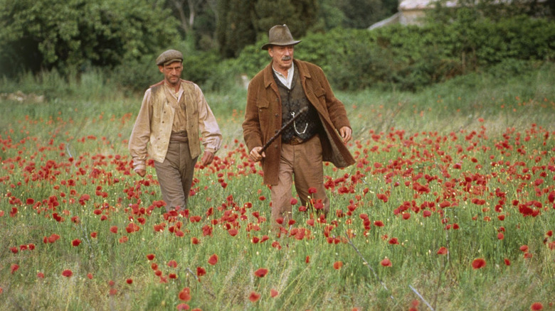 Daniel Auteuil as Ugolin and Yves Montand as Cesar, walking through a field in Jean De Florette