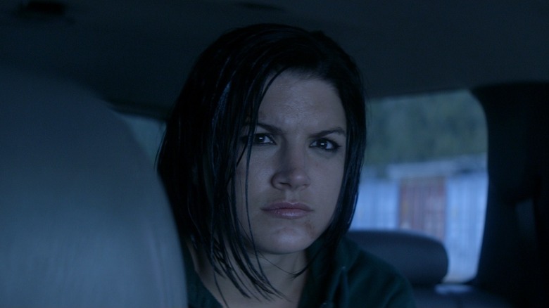 Gina Carano as Mallory Kane in Haywire, sitting in a car and looking off at something.