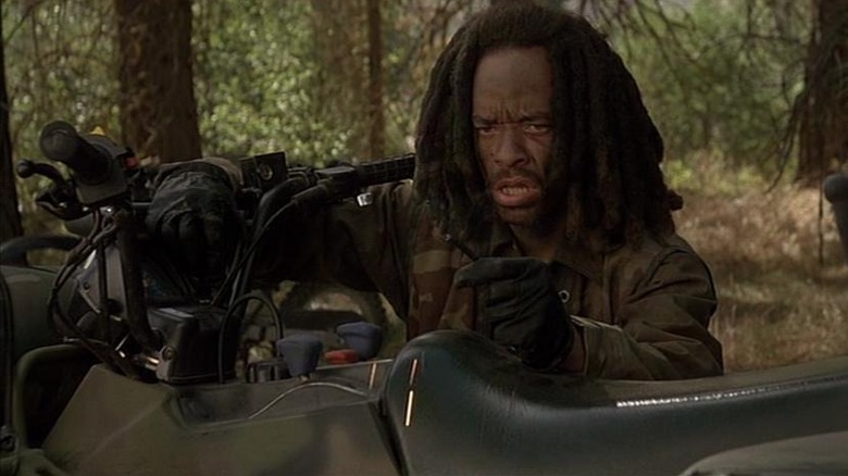 Ice-T as Jack Mason in Surviving the Game, seemingly hot-wiring a motorbike in the woods.