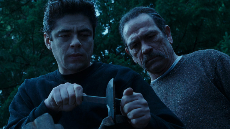 Tommy Lee Jones as L.T. Bonham and Benicio del Toro as Sergeant First Class Aaron Hallam sharpening a knife in The Hunted