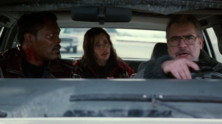 Geena Davis as Charly Baltimore / Samantha Caine, Samuel L. Jackson as Mitch Henessey, and Brian Cox as Dr. Nathan Waldman in The Long Kiss Goodnight, with Nathan driving a car as Samantha and Mitch look at him in shock.