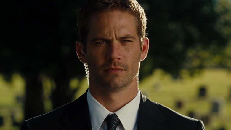 Paul Walker as Brian O'Conner wearing a suit at the cemetery in Fast & Furious