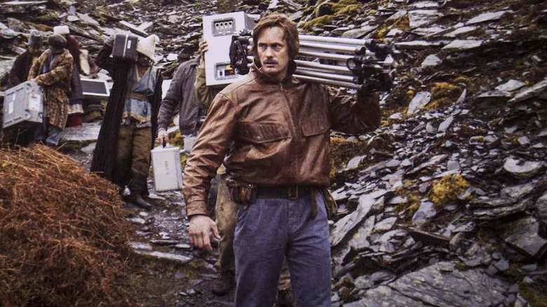 Alexander Skarsgård as Rainer Wolz, carrying film equipment through the mountains on Documentary Now