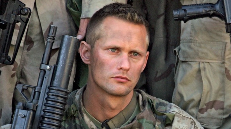 Alexander Skarsgård as Brad Colbert, holding a gun with soldiers on Generation Kill