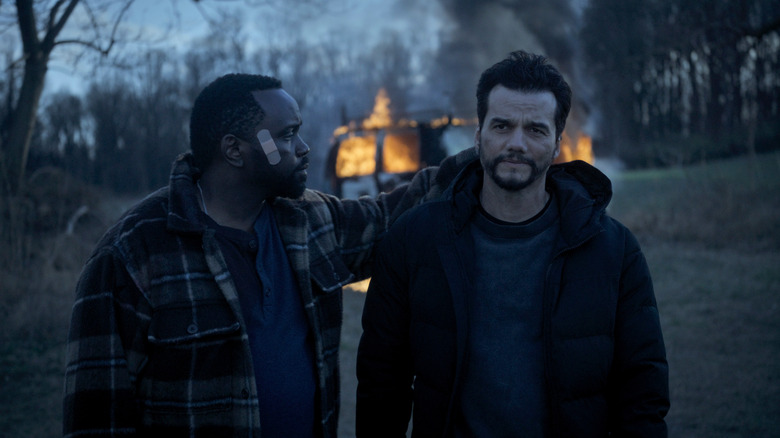 Brian Tyree Henry as Ray and Wagner Moura as Manny walking away from a flaming van in Dope Thief