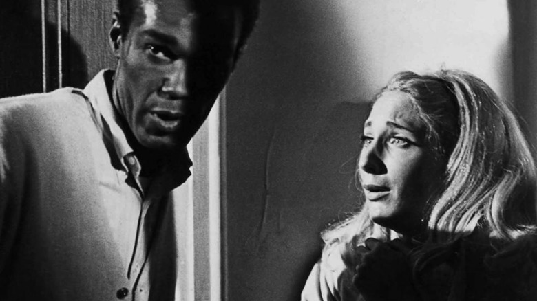 Ben (Duane Jones) looks away as Barbra (Judith O'Dea) stares at him in shock in Night of the Living Dead (1968)