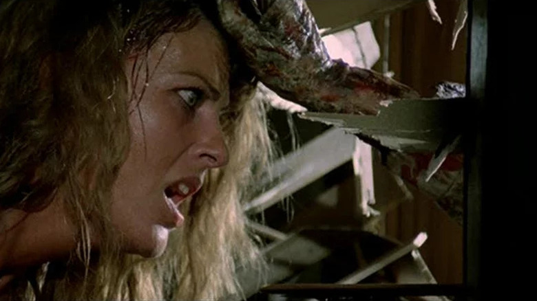 Paola Menard (Olga Karlatos) is dragged towards an exposed splinter in Zombi 2