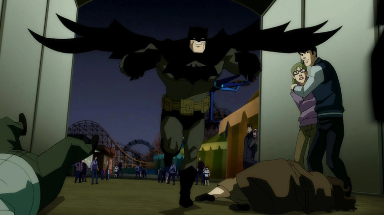 Batman (Peter Weller) running away from a theme park toward the camera with a couple of cowering people and bodies on the ground around him.