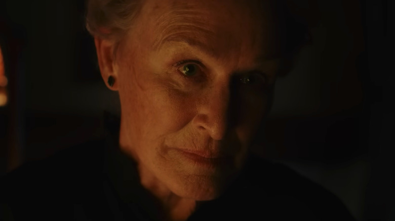 Glenn Close as Martha Delacroix, illuminated by fire in Wake Up Dead Man