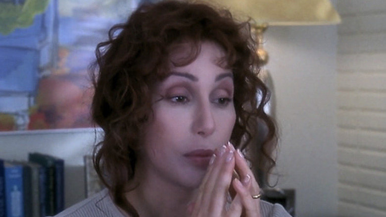 Cher with red hair as Dr. Beth Thompson holding her hands together and looking concerned in her oddice in If These Walls Could Talk