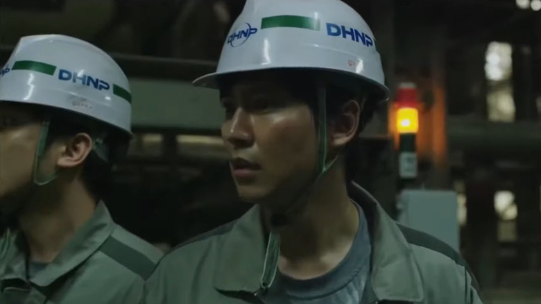 Kim Nam-gil as Jae-hyuk wearing work jumpsuit and white helmet next to colleague (face not visible) in Pandora