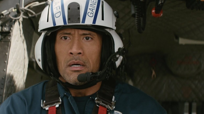 Dwayne Johnson as Ray wearing helmet, headphones, and headset while strapped into a helicopter in San Andreas
