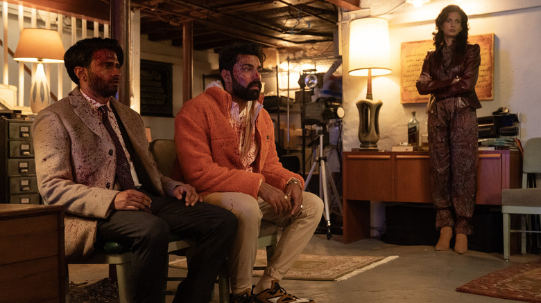 Asif Ali as Mir Dar and Saagar Shaikh as Raj Dar covered in blood as Poorna Jagannathan as Lucky stands behind them in Deli Boys