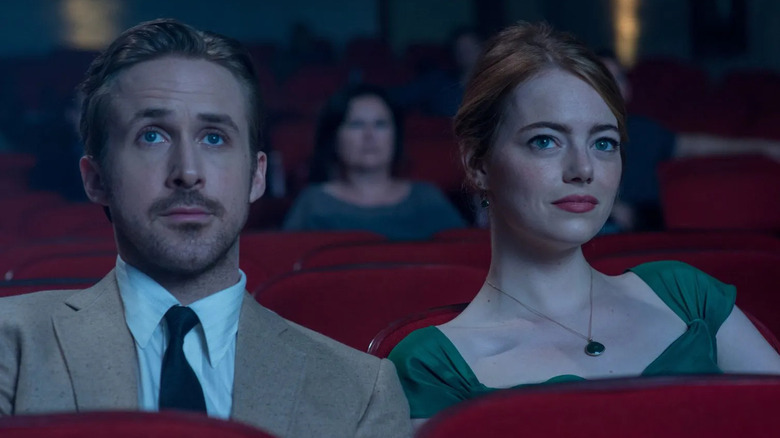 Ryan Gosling and Emma Stone watching a movie in a theater as Seb and Mia in La La Land