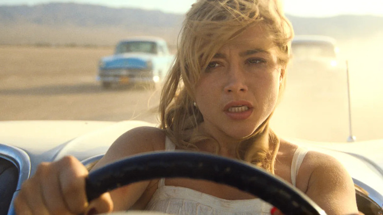 Florence Pugh as Alice Chambers driving away from two cars in Don't Worry Darling