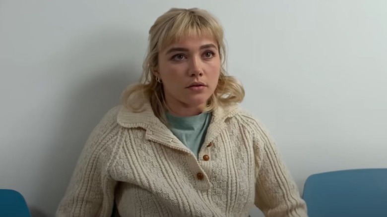 Florence Pugh as Almut sitting in a hospital waiting room in We Live In Time