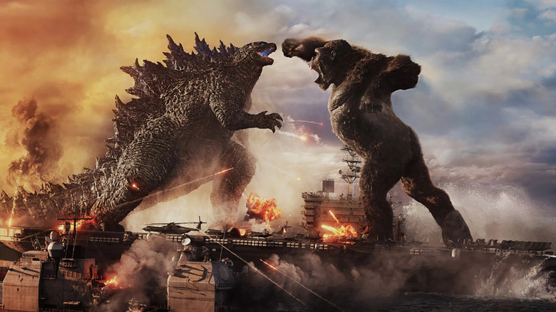 Kong throws a punch at Godzilla while they stand on an aircraft carrier in Godzilla vs. Kong