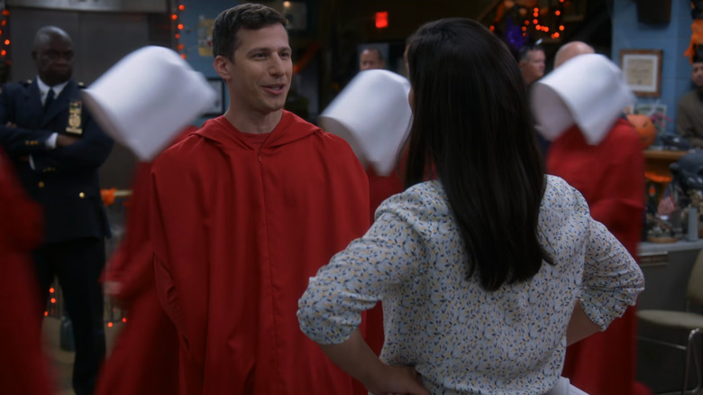 Jake (Andy Samberg) surrounded by people dressed as handmaids on Brooklyn Nine-Nine
