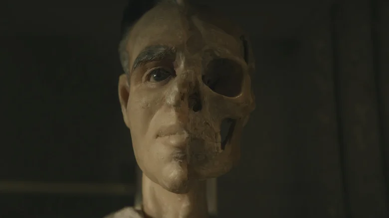 A model head with half of skull exposed on The Mortician