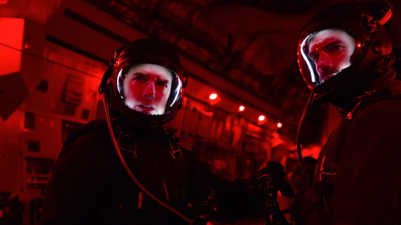 Tom Cruise as Ethan Hunt and Henry Cavill as August Walker standing in an aircraft wearing jumpsuits and helmets in Mission: Impossible — Fallout
