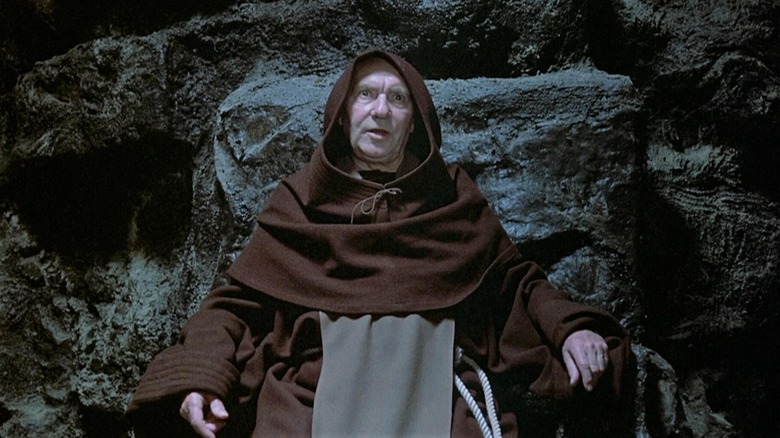 Ralph Richardson as The Crypt Keeper in Tales From The Crypt, wearing his hooded garb in his lair.