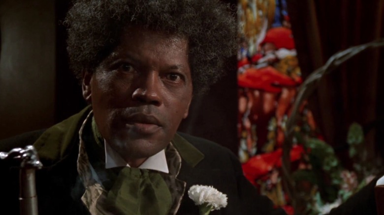 Clarence Williams III as Mr. Simms in Tales From The Hood, wearing his green zoot suit, looking right toward the camera.