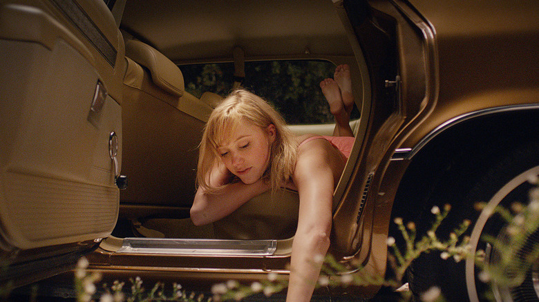 Maika Monroe as Jaime, crawling out of a car in It Follows.