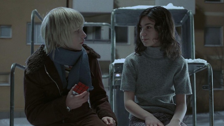 Kåre Hedebrant as Oskar and Lina Leandersson as Eli, sitting together in Let the Right One In.