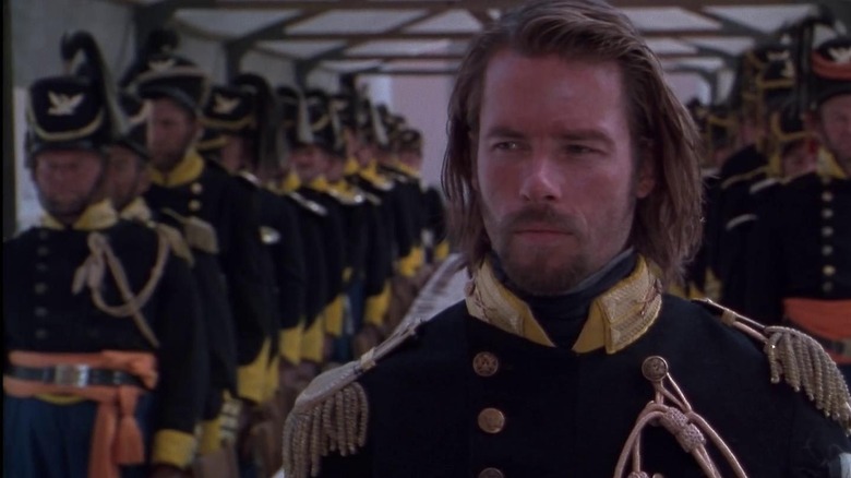 Guy Pearce as Captain John Boyd in Ravenous, in his army outfit with two lines of other troops standing behind him at attention in a tent.
