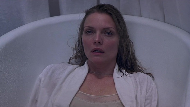 Michelle Pfeiffer as Claire Spencer, dressed and looking concerned as she sits in a bathtub looking up at something.