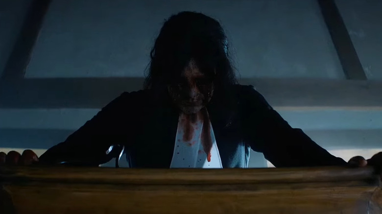 Michael Chandler as Cyrus Miller, leaning bloody over a pulpit in Fear Street Part Three: 1666