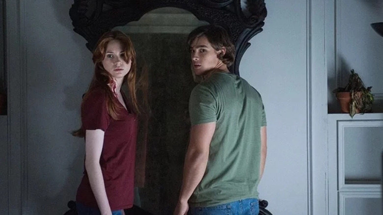 Kaylie Russell (Karen Gillan) and Tim Russell (Brenton Thwaites) turn away from a large mirror in Oculus