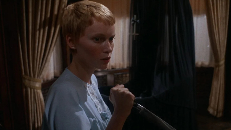 Mia Farrow as Rosemary Woodhouse in Rosemary's Baby, looking apprehensive as she wields a knife.