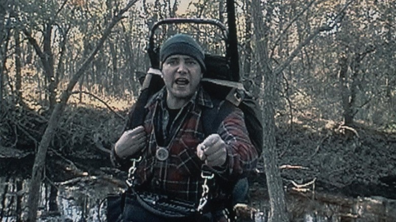 Michael C. Williams as Mike in The Blair Witch Project, standing in the forest and seemingly yelling at the person holding the camera.