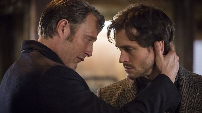Mads Mikkelsen as Dr. Hannibal Lecter and Hugh Dancy as Will Graham, embracing each other in Hannibal.