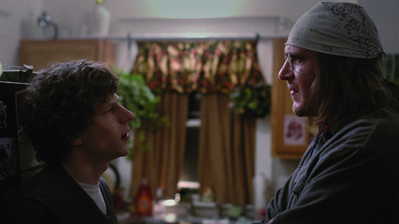 Jesse Eisenberg as David Lipsky and Jason Segel as David Foster Wallace looking at each other in a kitchen in End of the Tour