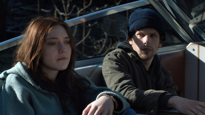 Dakota Fanning as Dena looking outward as Jesse Eisenberg as Josh looks at her while both sit on a boat in Night Moves